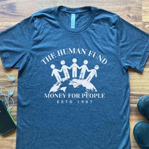 Camiseta del Fondo Humanitario, humor de parodia benéfica, divertida camiseta de George Scheme, trabajo, truco, dinero para la gente, regalo del mundo, comedia, comedia de situación, broma vaga.