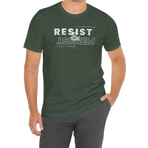 May include: A dark green t-shirt with a white graphic that reads "Resist & Persist".