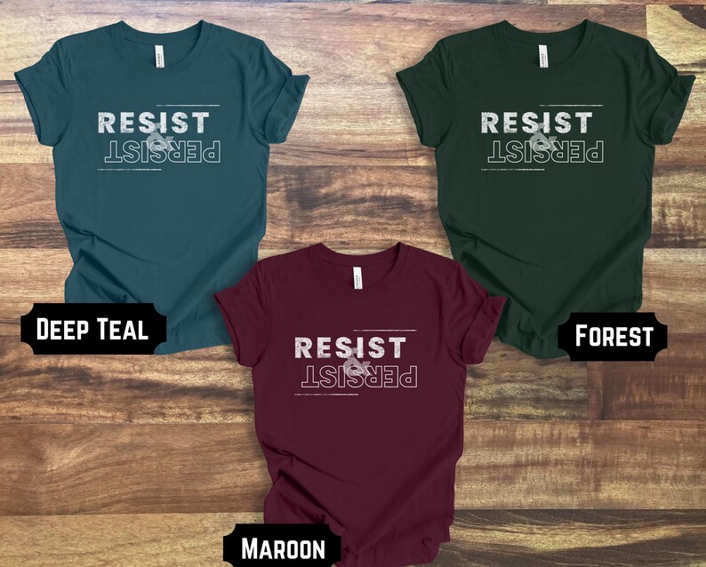 May include: Three t-shirts in different colors: deep teal, forest green, and maroon. Each shirt has the text "RESIST & PERSIST" printed on the front in white.