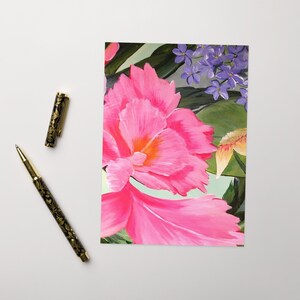 May include: A painting of a pink flower with a yellow center. The flower is surrounded by green leaves and purple flowers.