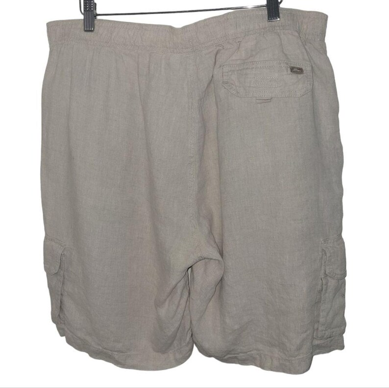 May include: A pair of light gray linen cargo shorts with a drawstring waist and two side pockets.