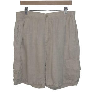 May include: Beige linen cargo shorts with a drawstring waist and two front pockets.