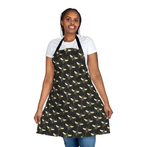 May include: A black apron with a repeating pattern of yellow and brown bees. The apron has adjustable straps and a large pocket in the front.