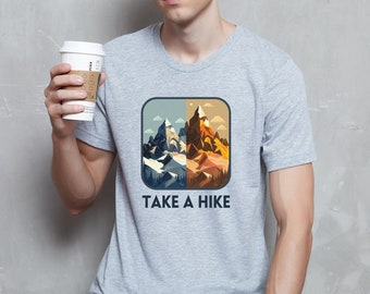 May include: A gray t-shirt with a graphic of a mountain range in blue, orange, and brown colors. The text "TAKE A HIKE" is printed below the graphic.