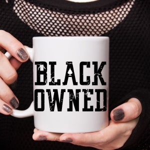 May include: White ceramic coffee mug with a black graphic that says "BLACK OWNED".
