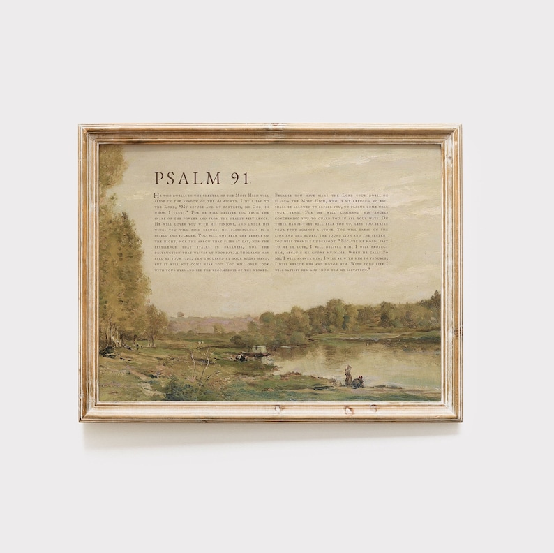 May include: A framed print of Psalm 91, a passage from the Bible, with a painting of a river scene in the background. The text is in a brown font on a white background. The painting depicts a river with trees and a small boat in the distance.
