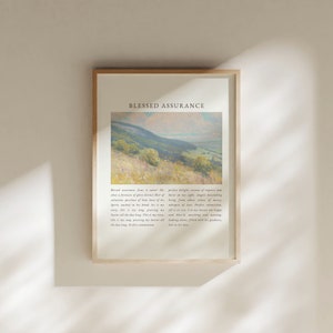 May include: A framed print featuring a light blue and green landscape painting. The text "Blessed Assurance" is at the top of the print. The text below the painting reads "Blessed assurance, Jesus is mine! Oh, what a fountain of glory divine! Here I raise my Ebenezer, here I'll rest in the Lord, His goodness is great, His mercy is sure, His love is my portion, His blood is my cure. Spirit, washed in His blood, I am His, His love is my song, His praise is my story. This is my song, this is my story, this is my song, this is my story. I'll sing it all day long, praising my Savior all the day long. Perfect commission."