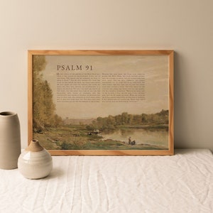 May include: A framed print of Psalm 91 with a watercolor painting of a river scene. The text is in brown font on a beige background. The painting depicts a river with trees on either side and a few figures in the distance.