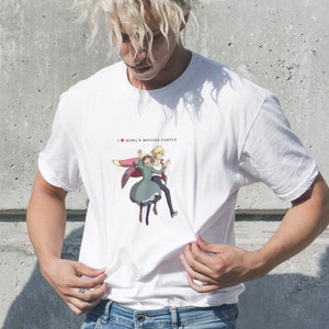 May include: White t-shirt featuring a graphic print of a couple from the animated film "Howl's Moving Castle". The text "I ♥ Howl's Moving Castle" is printed above the graphic.