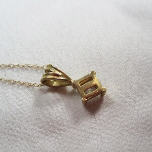 May include: A gold chain necklace with a pendant shaped like the Roman numeral 'II'. The pendant has a simple design with a smooth finish.