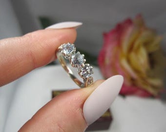 Engelsk trilogiring i 9 karat vitguld med blå topas och accentdiamanter, storlek 6 1/4, TB267