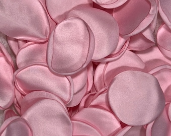 Puede incluir: Un montón de pétalos de rosa de satén rosa. Los pétalos son suaves y delicados, perfectos para agregar un toque de romance a cualquier ocasión.