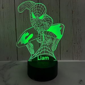 May include: Green 3D printed night light featuring a superhero character with a web design. The name "Liam" is printed below the character.