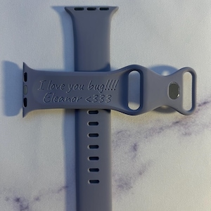 May include: A purple silicone Apple Watch band with the text "I love you bug!!!! Eleanor <333" engraved on it.