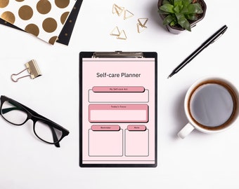 Puede incluir: Un planificador de autocuidado rosa en un portapapeles con secciones para "Mi acto de autocuidado", "Enfoque de hoy", "Recordatorio" y "Nota". El planificador está sobre una superficie blanca con una taza de café, unas gafas, una suculenta en maceta y clips de papel dorados.