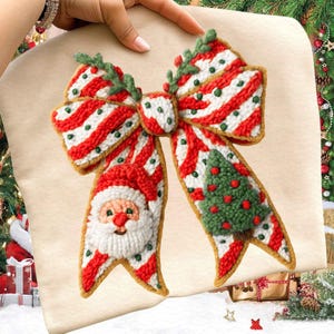Pode incluir: Decora&ccedil;&atilde;o festiva de la&ccedil;o de Natal com sec&ccedil;&otilde;es listradas em vermelho e branco, detalhes verdes e um rosto de Papai Noel em uma extremidade. Uma &aacute;rvore de Natal verde est&aacute; na outra extremidade. O la&ccedil;o &eacute; feito de um material texturizado.