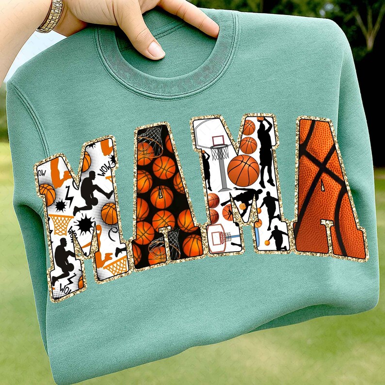 Puede incluir: Una sudadera verde azulado con la palabra "MAMA" en letras grandes y decorativas. Las letras est&aacute;n rellenas de balones de baloncesto, siluetas de baloncesto y redes. Las letras est&aacute;n delineadas con purpurina dorada.