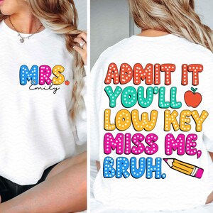 Pode incluir: Camisola branca com o texto "MRS. Emily" em letras coloridas com bolinhas brancas na frente e "ADMIT IT YOU'LL LOW KEY MISS ME, BRUH." em letras coloridas com bolinhas brancas nas costas.