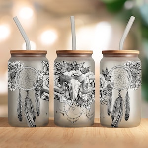 May include: Three frosted glass tumblers with bamboo lids and clear straws. Each tumbler features a different black and white design with a dreamcatcher, feathers, flowers, and a skull.