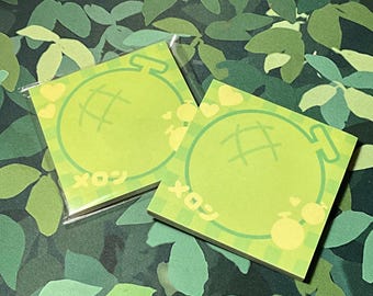 May include: Two square sticky notes with a light green melon design. Each note features a melon illustration, hearts, and Japanese text. The notes are on a green and white checkered pattern.