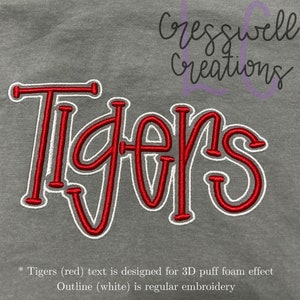 May include: Red embroidered "Tigers" text with a white outline. The text is designed for a 3D puff foam effect. The outline is regular embroidery.