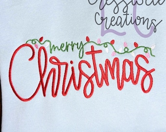 May include: A light blue sweatshirt with the embroidered words "Merry Christmas" in red script. The word "merry" is in green script, and the design includes a string of Christmas lights.