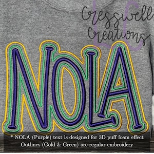 May include: Embroidered design of the word "NOLA" in purple with gold and green outlines. The text is designed for a 3D puff foam effect, while the outlines are regular embroidery.