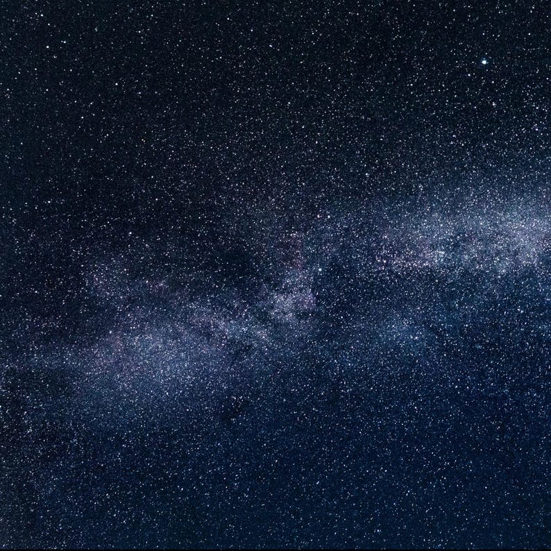 May include: A dark blue night sky with a band of white stars, the Milky Way, stretching across the image.