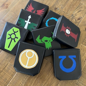 May include: Nine black square cushions with different colored symbols on them. The symbols include a red bird, a green sword, a green circle with a yellow center, a green skull, a blue circle with a white center, a blue circle with a white center, a blue circle with a white center, a blue circle with a white center, and a blue circle with a white center.