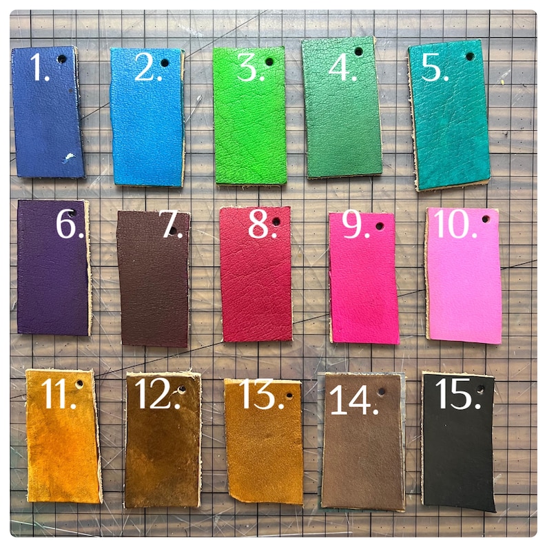 Fifteen leather color swatches labeled 1 to 15 in various shades: blue, turquoise, green, teal, purple, brown, tan, red, pink, black, yellow, and gold. Displayed on a cutting mat, ideal for custom leathercraft or DIY projects