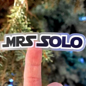 May include: A clear sticker with the text "MRS SOLO" in black letters with a white outline.