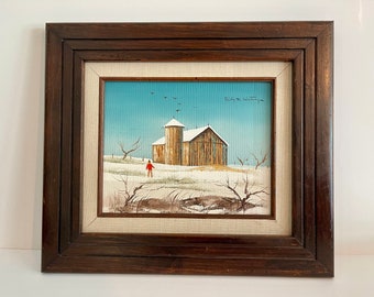 May include: A framed painting of a winter scene with a barn and a single figure walking in the snow. The sky is blue and there are birds flying overhead. The painting is signed "Nicky de Volting".