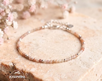 May include: A delicate bracelet featuring small, faceted, light brown gemstone beads interspersed with tiny, polished silver-tone metal spheres. The jewelry piece includes a silver-tone chain extender and a clasp, with the text JOSEPHINE visible.