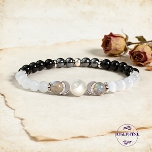 Può includere: Un braccialetto di perline con perline di onice nero, ematite e selenite bianca. Il braccialetto include ciondoli a mezzaluna argentati e accenti di labradorite iridescente. Il braccialetto è esposto su uno sfondo di carta vintage.
