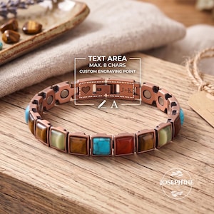 Puede incluir: Una pulsera de eslabones color cobre con incrustaciones cuadradas alternas de ojo de tigre, turquesa y piedra roja. El cierre muestra un icono de corazón y el texto J+K, con un diagrama que indica un punto de grabado personalizado de 8 caracteres.