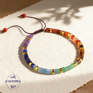 May include: A colorful beaded bracelet with a rainbow of gemstones, including amethyst, lapis lazuli, and carnelian. The bracelet features gold-colored spacers and a brown cord closure. The image includes the text "JOSEPHINE" in a circular logo.