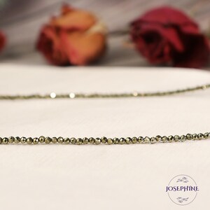 May include: A gold-toned necklace made of small, faceted pyrite beads. The necklace is delicate and simple, and would make a great everyday piece of jewellery.