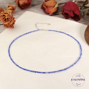 May include: A delicate blue gemstone necklace with a silver clasp. The necklace is made of small, round beads and is perfect for layering.