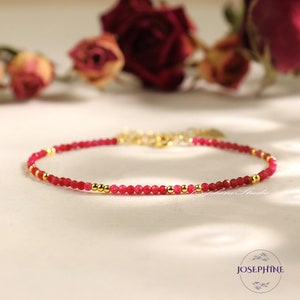 May include: A delicate red gemstone bracelet with gold beads. The bracelet is made with small, round beads and has a simple, elegant design.