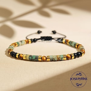 May include: A beaded bracelet featuring a mix of green, brown, gold, and black beads. The bracelet has a sliding knot closure and is displayed on a neutral surface. The bracelet is a piece of jewelry.