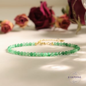 May include: A delicate green gemstone bracelet with a gold clasp. The bracelet is made of small, round beads and is perfect for everyday wear.