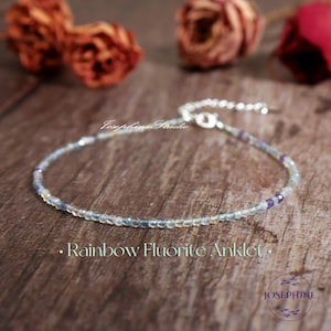 May include: A delicate rainbow fluorite anklet with small, faceted beads in shades of blue, green, and purple. The anklet has a silver chain and clasp. The text "Rainbow Fluorite Anklet" is displayed on the image.