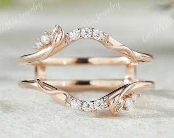 May include: Rose gold ring enhancer with a delicate, vine-like design and small, sparkling diamonds.