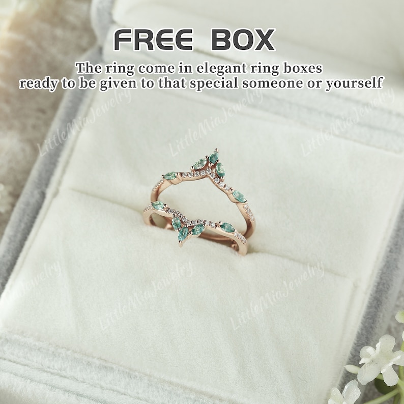 May include: A pair of delicate, rose gold rings with a V-shaped design. The rings are adorned with small, pear-shaped green gemstones and sparkling white diamonds. The rings are displayed in a white velvet ring box. FREE BOX.