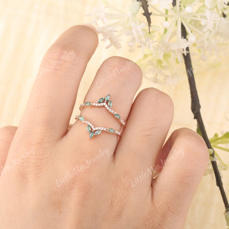 May include: A delicate, curved wedding band set with a row of small, round diamonds and a row of marquise-shaped green gemstones. The band is made of rose gold.