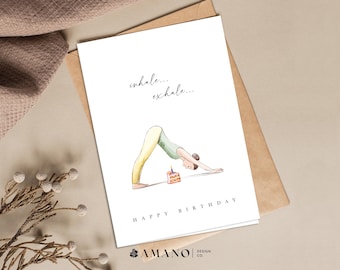 May include: A birthday card with a watercolor illustration of a person doing a downward-facing dog yoga pose with a birthday cake in front of them. The text on the card reads "inhale... exhale... Happy Birthday".