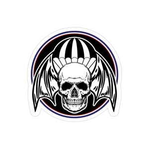 May include: A black and white sticker featuring a skull with bat wings and a parachute design. The skull is centered, with detailed teeth and eye sockets. The design is framed by a black circle with red and blue borders.