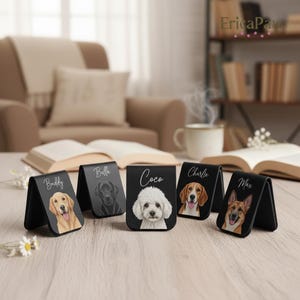 Puede incluir: Clips magnéticos negros para billetes con retratos de perros y nombres: Buddy, Bella, Coco, Charlie y Max. Cada clip muestra una raza de perro diferente, con el nombre del perro en escritura manuscrita. Los clips se exhiben sobre una superficie de madera clara.