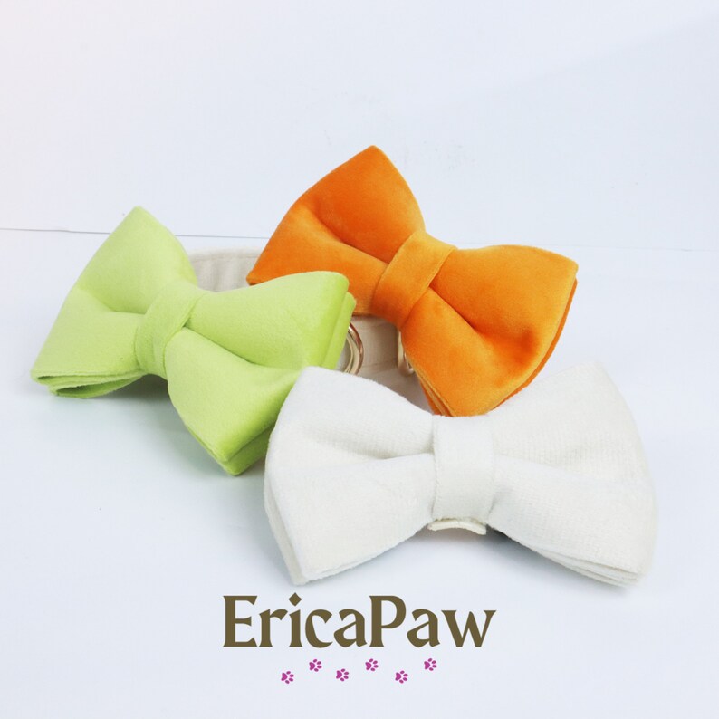 Pu&ograve; includere: Tre papillon in velluto di diversi colori: verde, arancione e bianco. I papillon sono disposti su una superficie bianca.