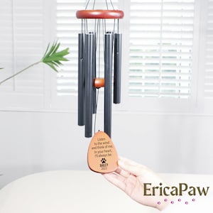 May include: Black metal wind chime with a wooden top and a brown wooden tag that reads "Listen to the wind and think of me. In your heart, I'll always be. BAILEY 2023"